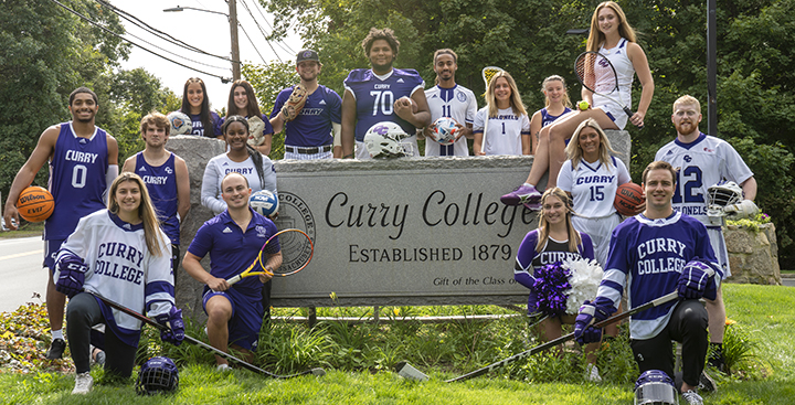 Curry College Coloneles representing all of the NCAA teams and Cheerleading pose for a photo at the front gate