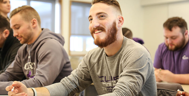 A Curry College student smiling in class