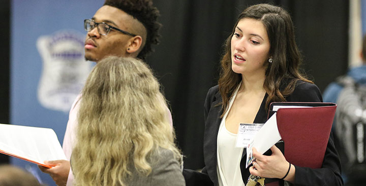 A student speaks with a recruiter at a Curry College Center for Career Development Career and Internship event