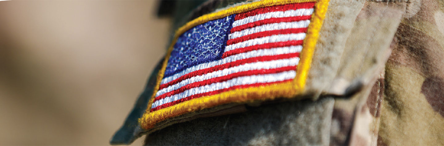 An American flag patch on a military uniform represents veteran students services at Curry College