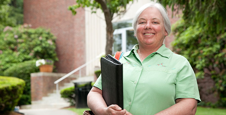 A Curry College Master of Science in Nursing - Nurse Administrator student poses for a photo on campus