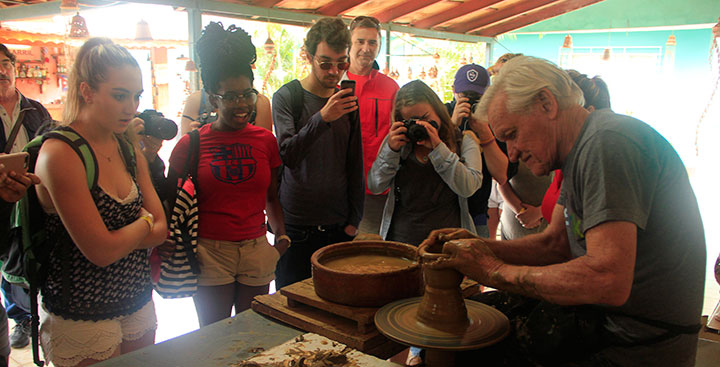 Curry College Study Abroad students in Cuba watch a man make pottery