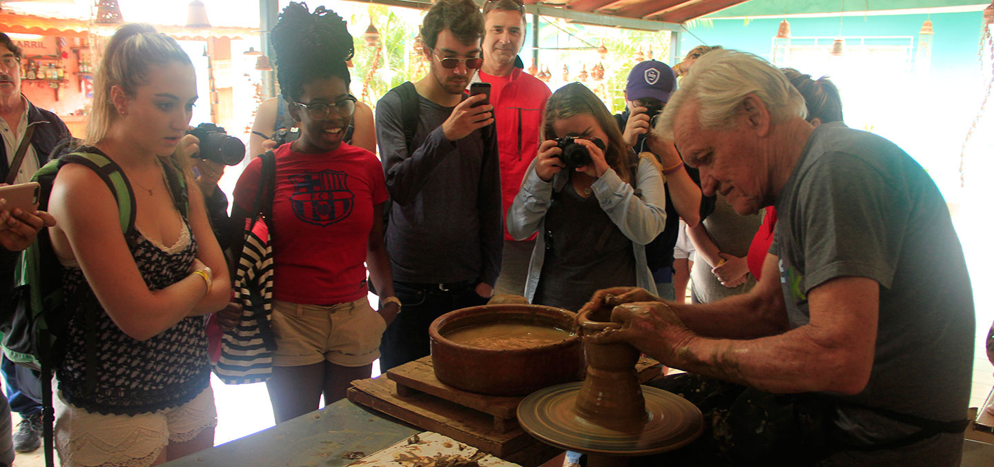 Curry College Students Abroad in Cuba watch a man make pottery
