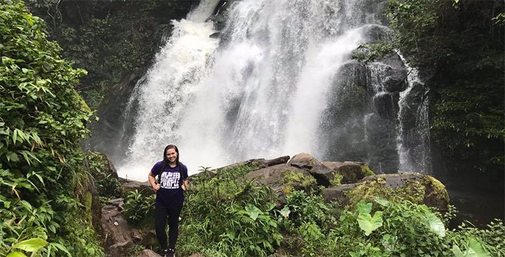 Curry student abroad in Thailand under a waterfall