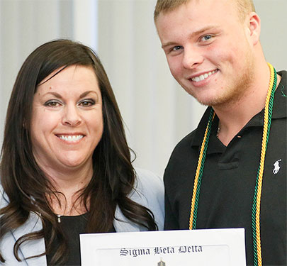 A student receives his Business Honor Society certificate