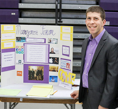 A Curry College Management Forum student poses for a photo