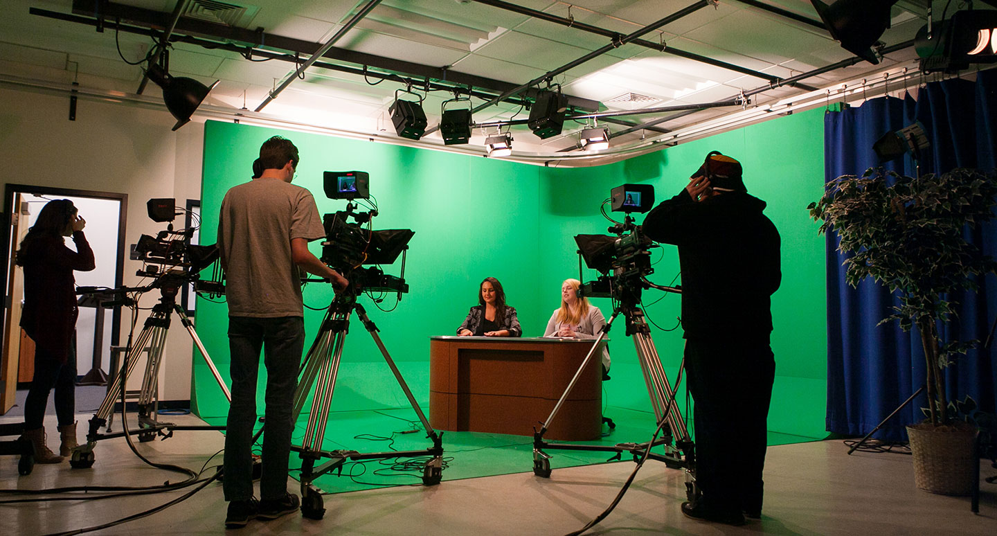 Students run cameras for a television news program at the Curry College Hirsh Communication Center