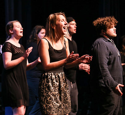 Curry College Sing! student performers belt out a tune on stage