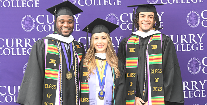 Curry College students smiling at Graduation