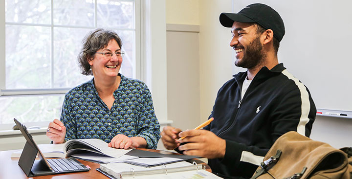 A Program for Advancement of Learning (PAL) professor assists a student with assignments at Curry College