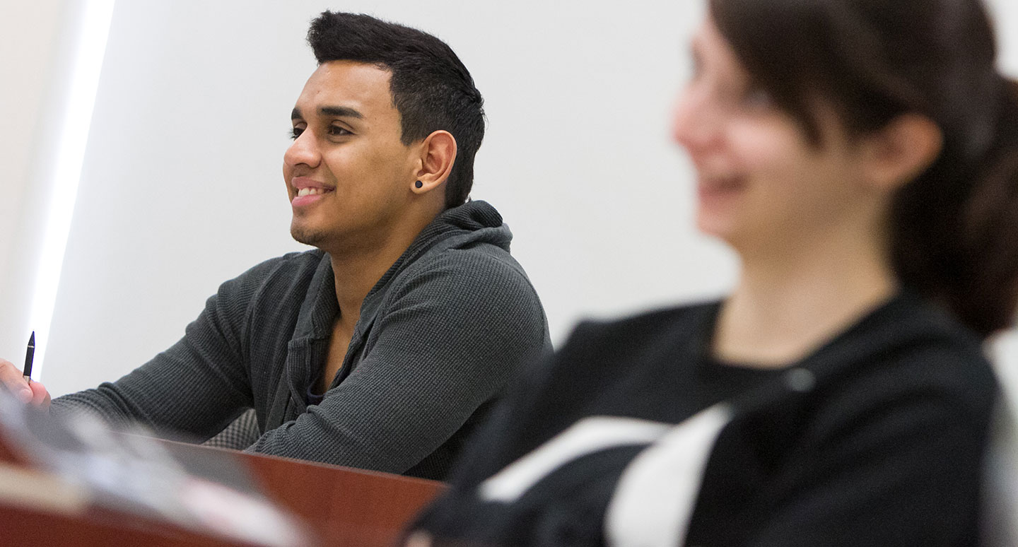 Students smiling in class at Curry College