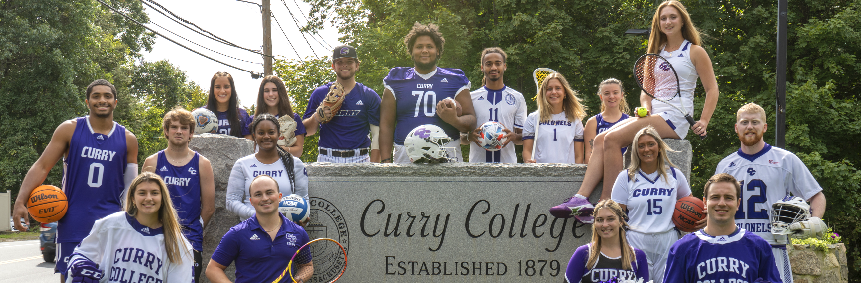 Curry College student-athletes from every sport pose for a photo at the front gate of campus