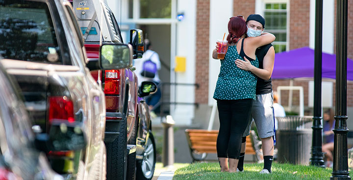 A Curry College parent hugs her son goodbye