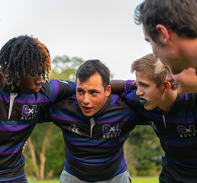 Curry College Men's Rugby players in a huddle