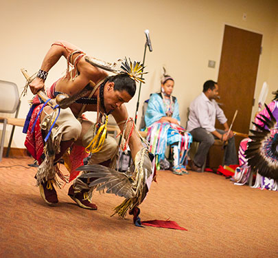 A Native American dancer performs on campus