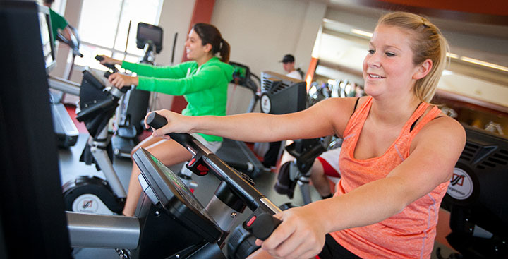 Students exercise together on bikes at the Fitness Center