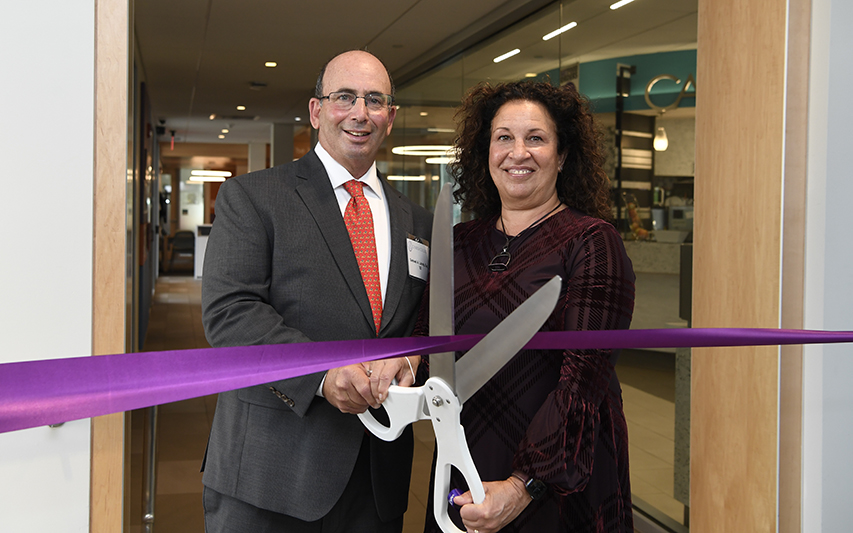 Sam '82 and Laurie Landy cut the ribbon for the opening of the Landy Family Student Services Area at Curry College