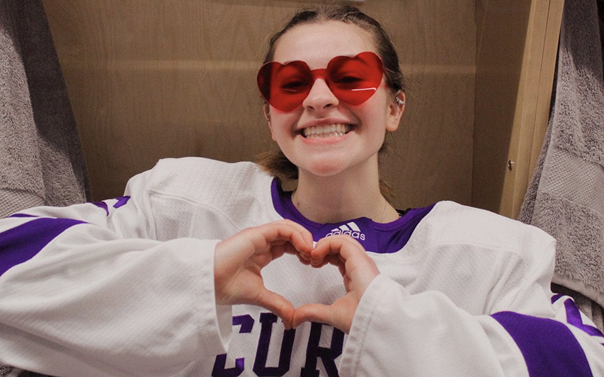 Meagan Young '25 makes heart with hands in hockey uniform