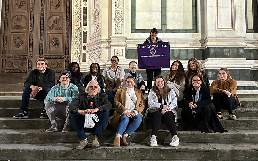 Students pose with Curry College flag in Florence, Italy