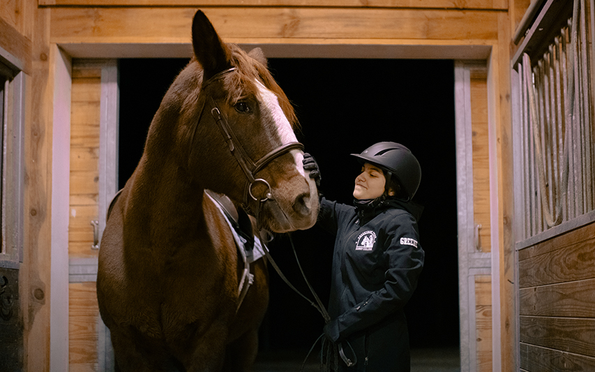 Maddy Greene '26 poses next to her horse 