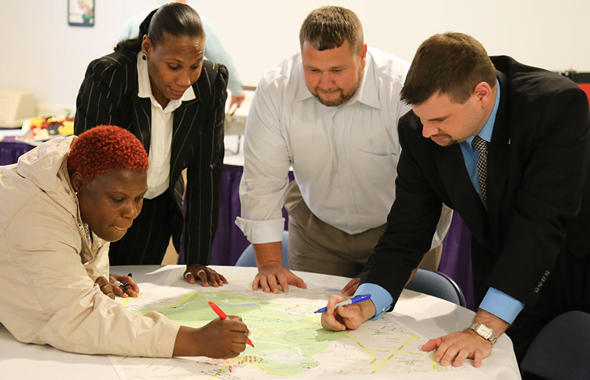 Students in class collaborate on a project while pursuing a Curry College Master of Arts in Criminal Justice Degree