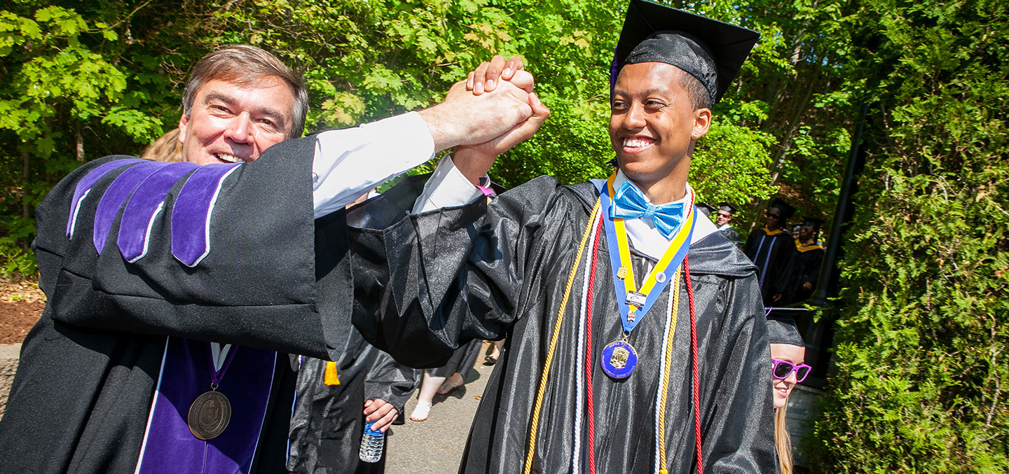 Curry College student gets a high five from the President on Commencement Day