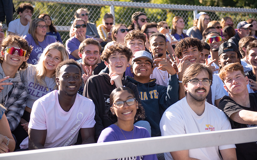 Fans in the football stands at Curry College Homecoming and Family Weekend