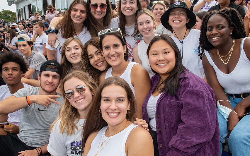 Fans in the football stands at Curry College Homecoming and Family Weekend