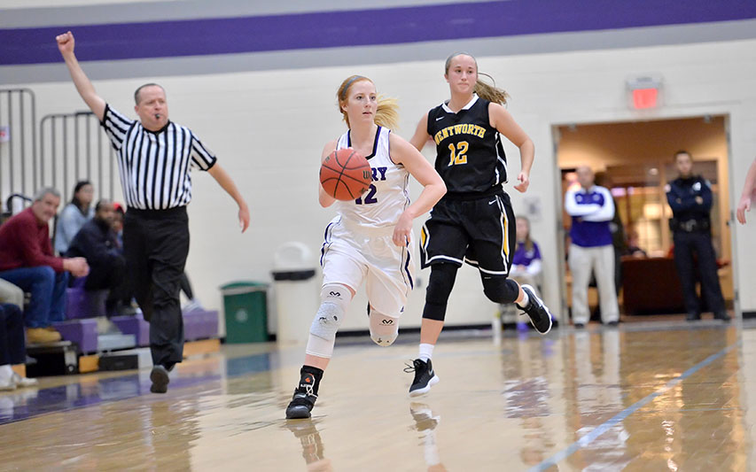 Student-athlete Emily Irwin dribbles down the basketball court in the Curry College Katz Gymnasium.