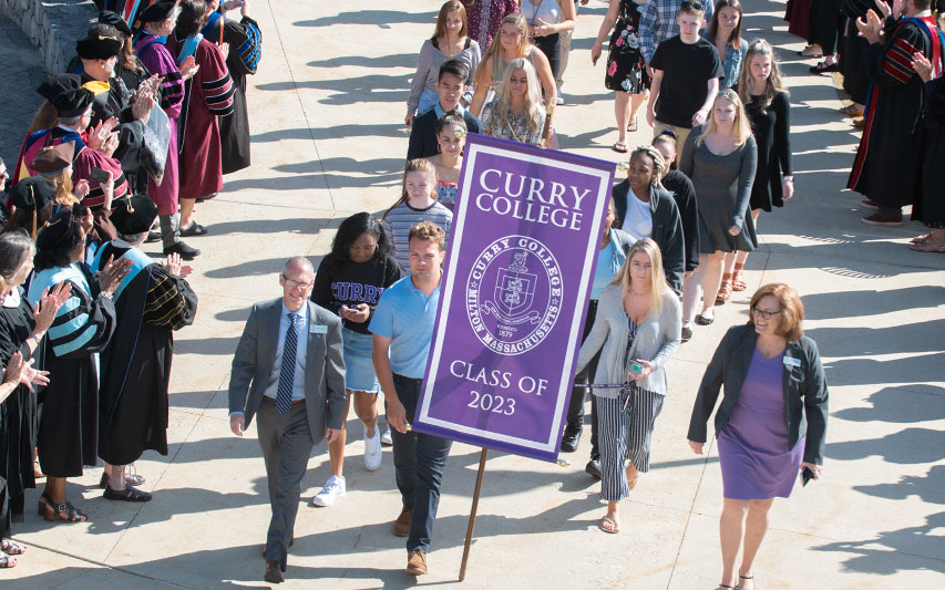 Curry College faculty and staff line the walkway to the Student Center, applauding members of the Class of 2023