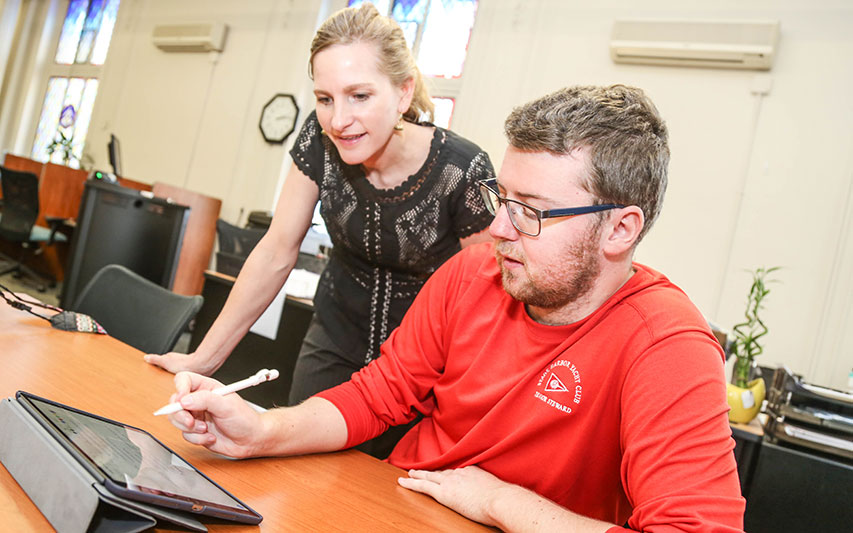 Dr. Laura Vanderberg works with a Curry College PAL student