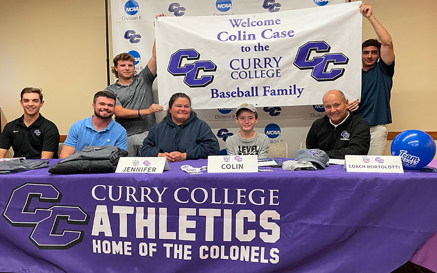 Colin Case poses with baseball coach and family for Team IMPACT signing