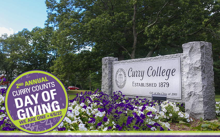 Curry College front gate sign with Day of Giving logo