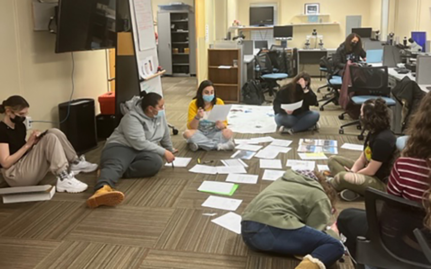 Forensic Science students huddled together working on cold cases