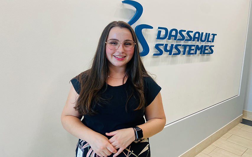 Olivia Perron poses in front of Dassault Systemes signage during her summer internship
