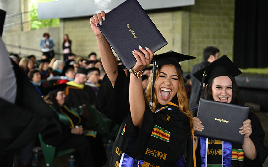 A proud Curry College graduate holds up her diploma