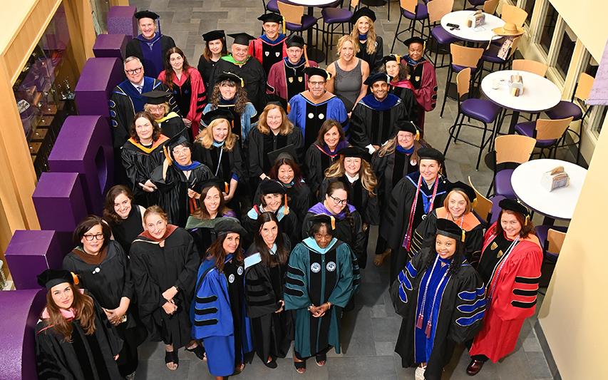 Curry faculty pose in the hall of champions 