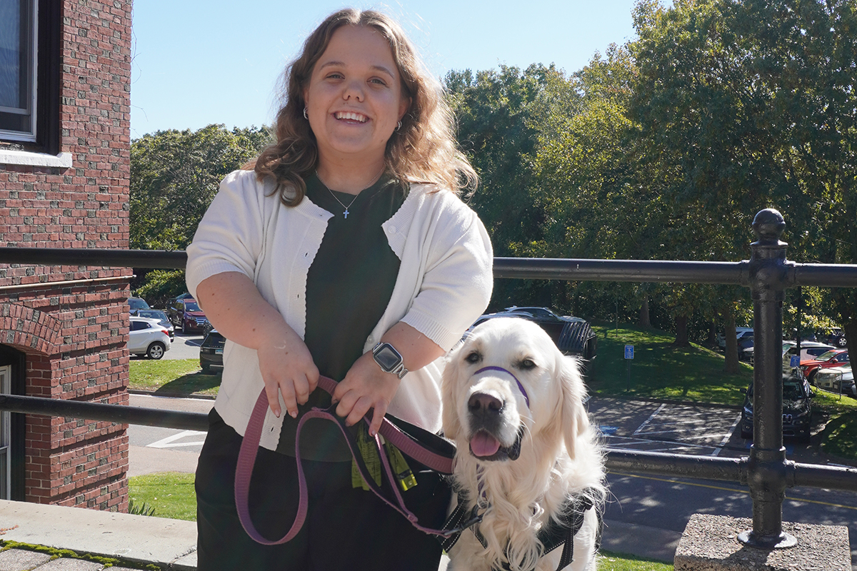 Taylor Nault poses with Graham the dog outside of PAL