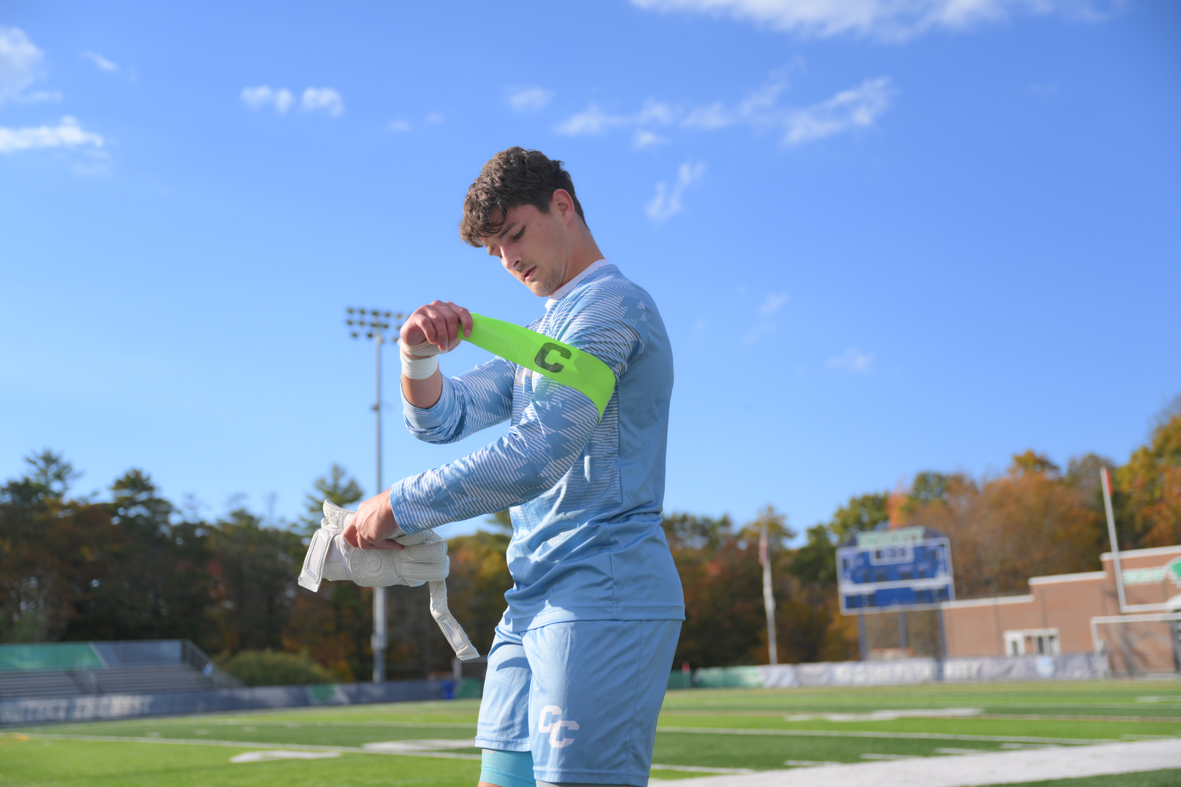 Brendan laces up for a soccer game, tugging on his captain badge