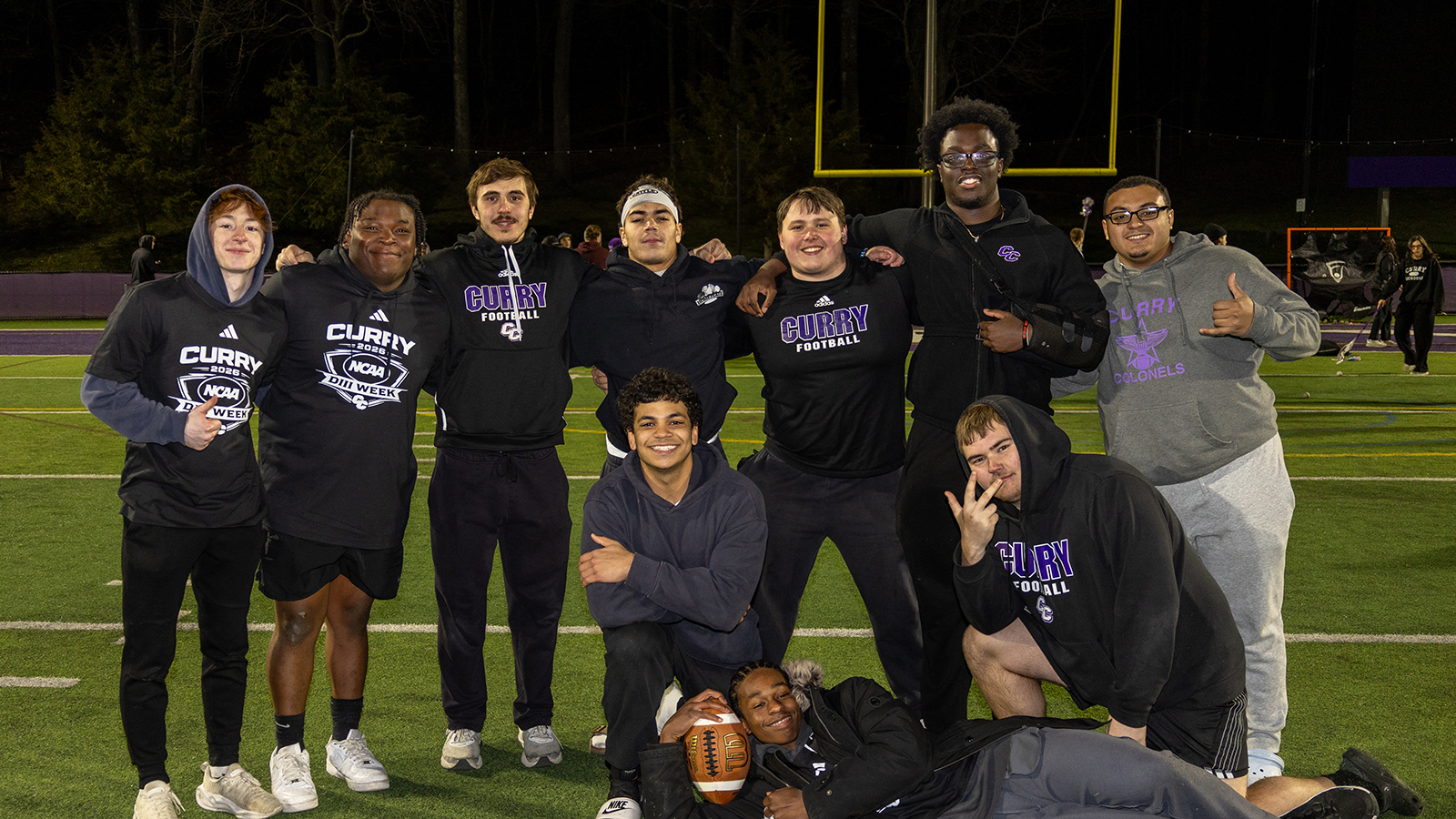 Student-athletes pose with smiles on Katz Field During Game Night