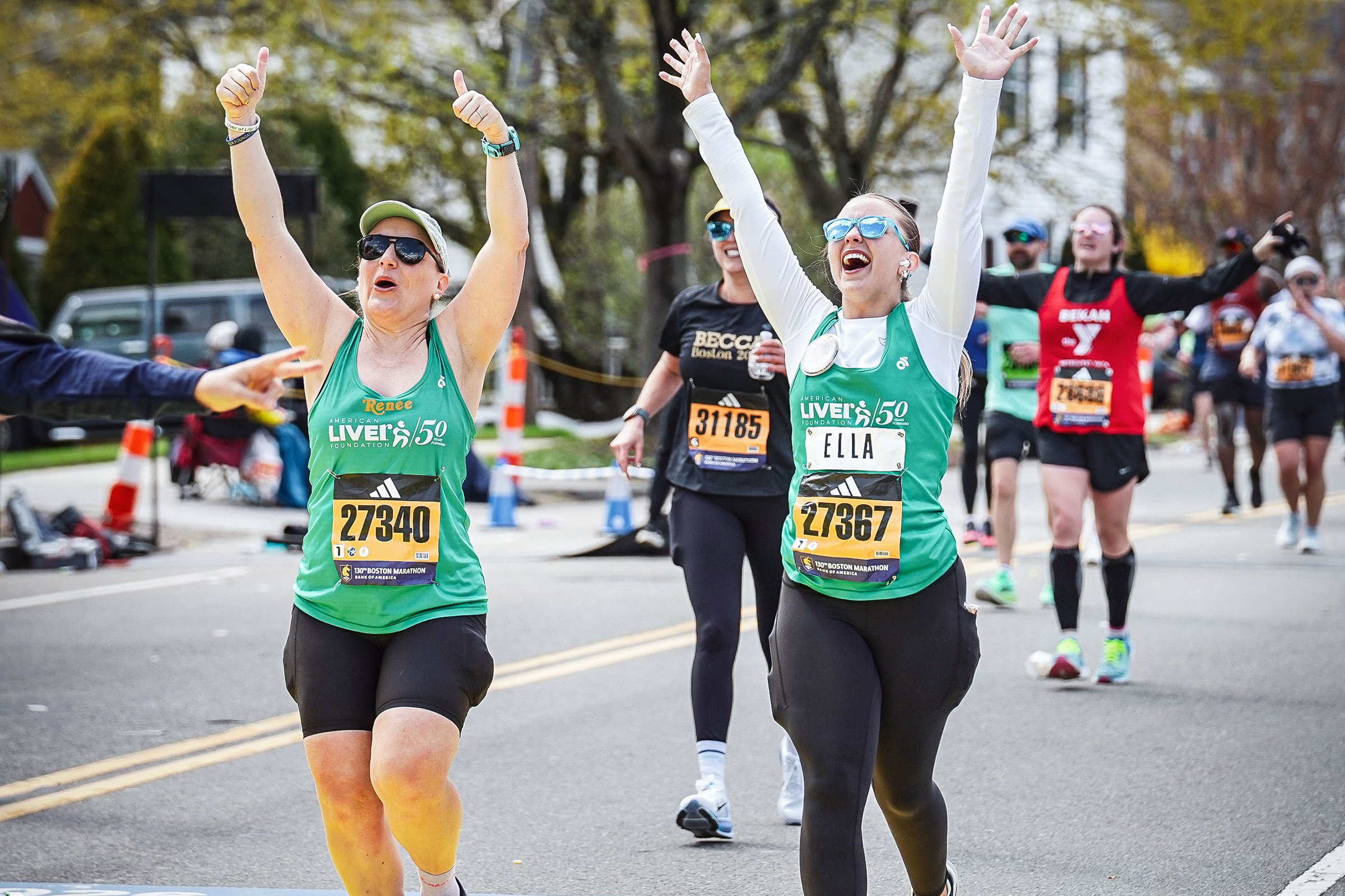 Ella puts hands up in the air while running marathon