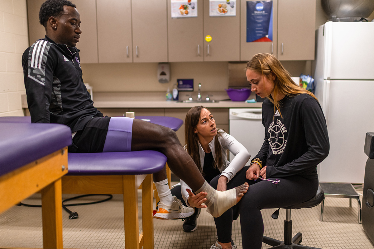Professor tapes up an ankle in athletic training room
