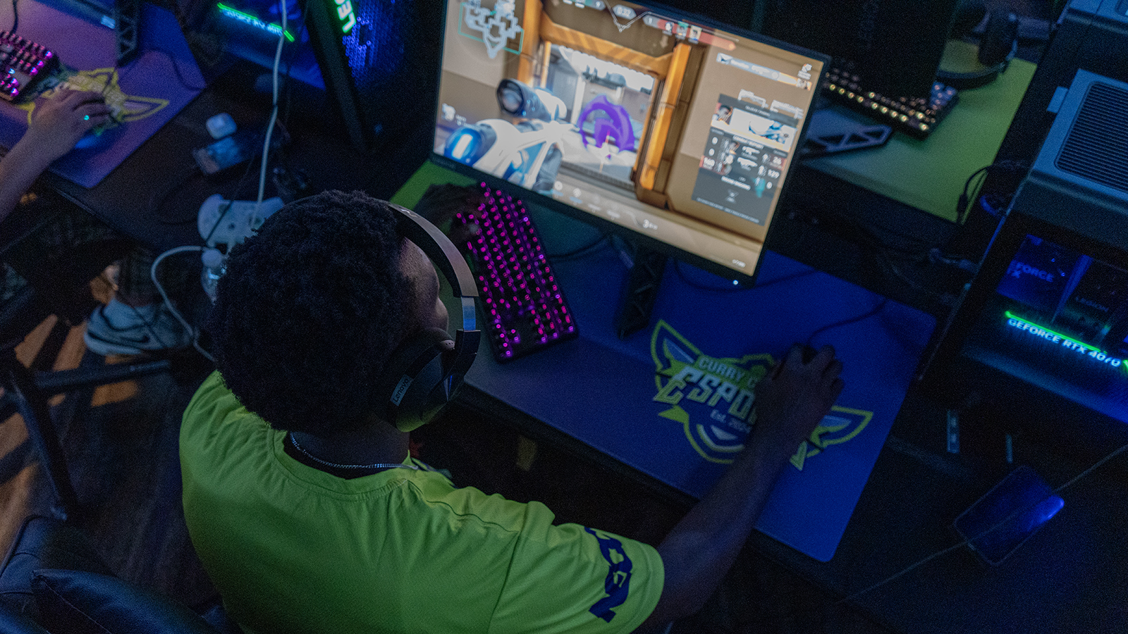 Student is locked in playing video games in a dark Esports lounge