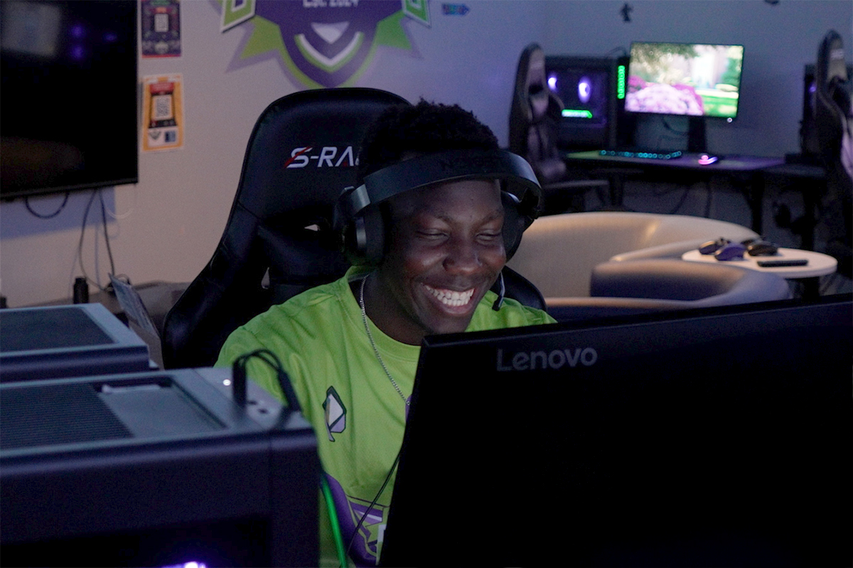 Marvin smiles while playing a video game in Esports lounge