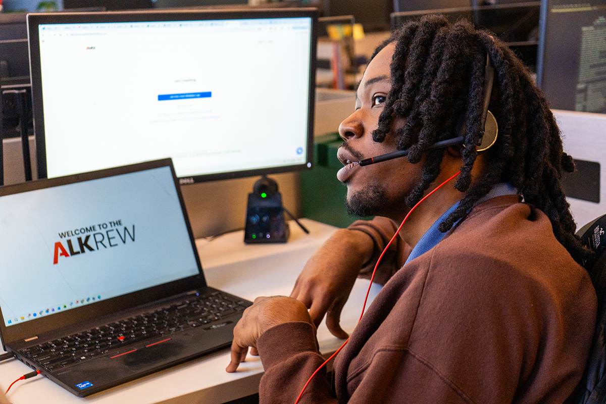 Roshaine engages with clients on phone while working at desk