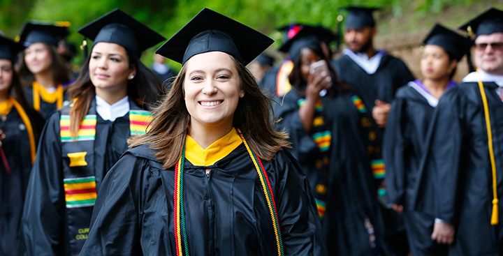 A Curry College student proudly marches at Commencement