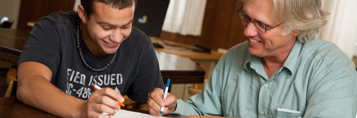A Curry College professor helps a student in the Academic Enrichment Center