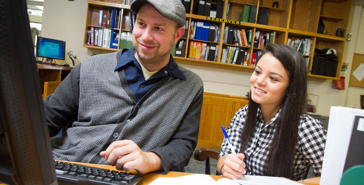 A Curry College library faculty helps a student find what she needs