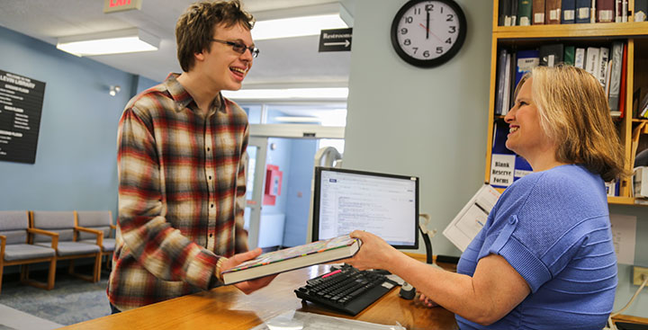 Students speaks with a Levin Library faculty member at Curry College