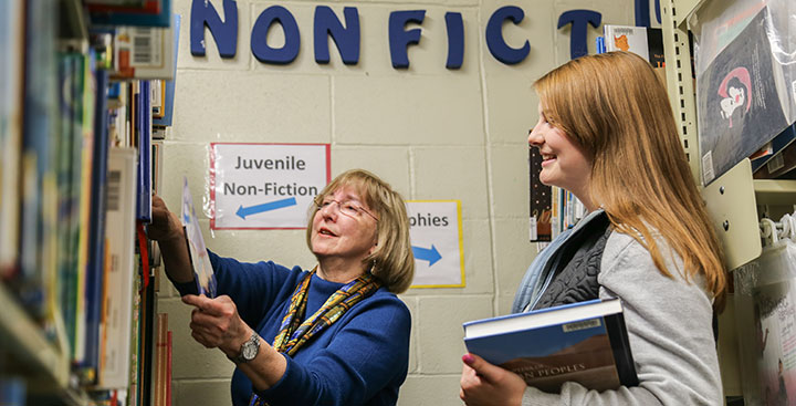A librarians in the Education Resource Center helps a Curry College student